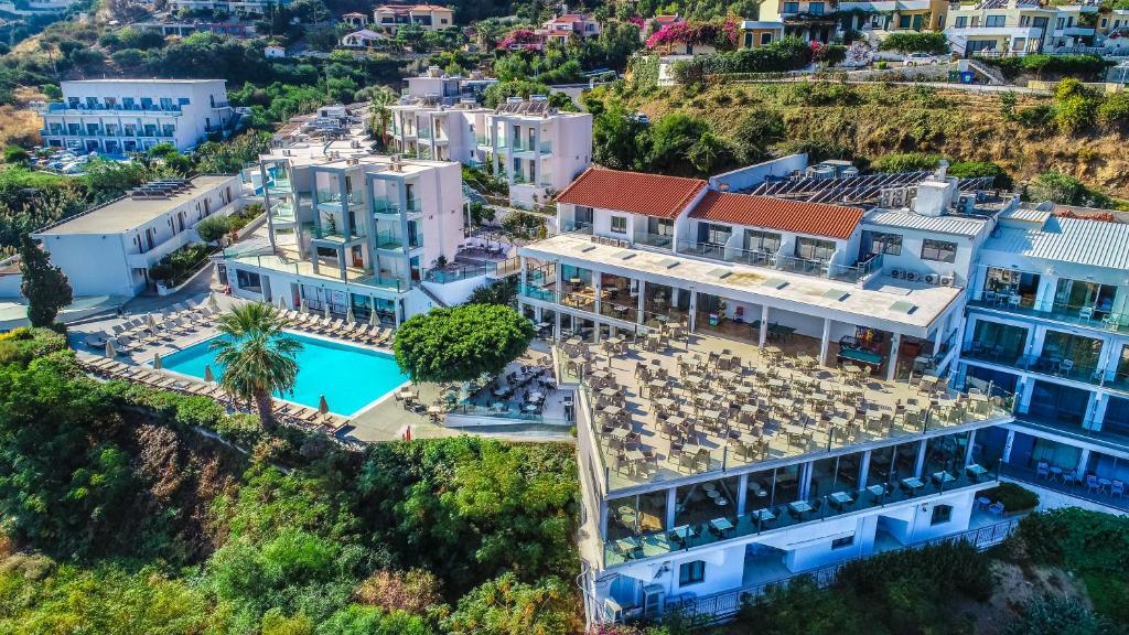Panorama Village Hotel teritorija ar plašu āra baseinu un restorāna terasi saulainā piekrastē