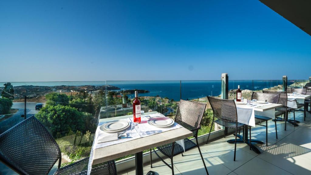 Panorama Village Hotel āra restorāna terase ar klātiem galdiem un skatu uz jūru