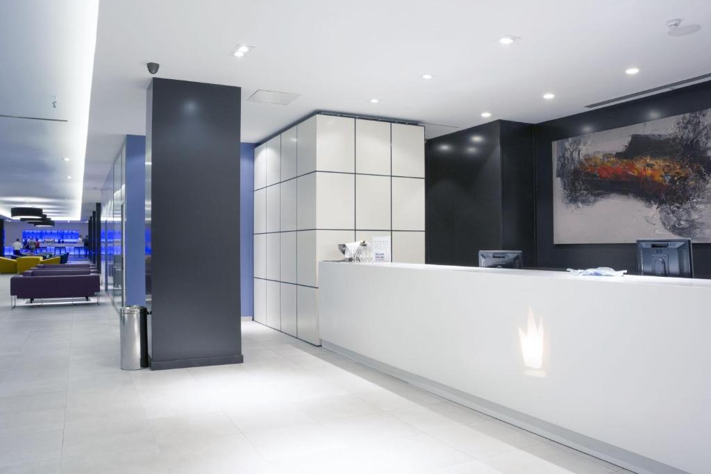 Mūsdienīga viesnīcas reģistratūras zona ar elegantu dizainu un minimālistisku interjeru. Gaiša, plaša telpa ar profesionālu apgaismojumu un modernām mēbelēm.