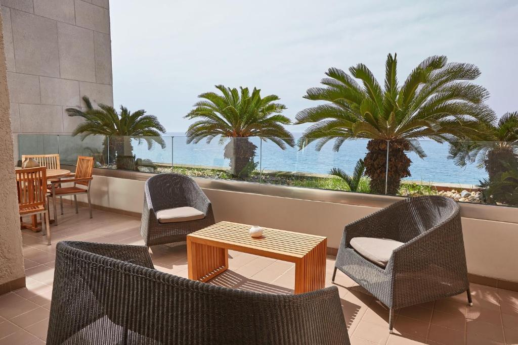 Terase ar skatu uz jūru pie Sheraton Rhodes Resort, ērti krēsli un galds.