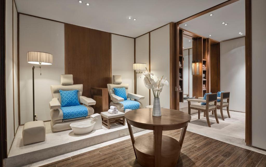 Mūsdienīga spa telpa ar komfortablām atpūtas krēslām, koka mēbelēm un maigu apgaismojumu, radot relaksējošu atmosfēru. Ideāli piemērota mierīgai atpūtai un skaistumkopšanas procedūrām.