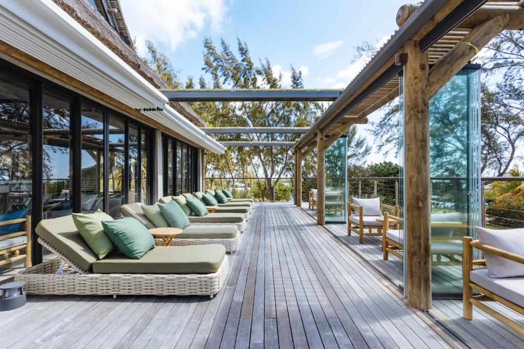 Mūsdienīga terase ar atpūtas krēsliem un spilveniem, kas piedāvā komfortu un skatu uz dabu. Ideāla vieta relaksācijai un atpūtai.