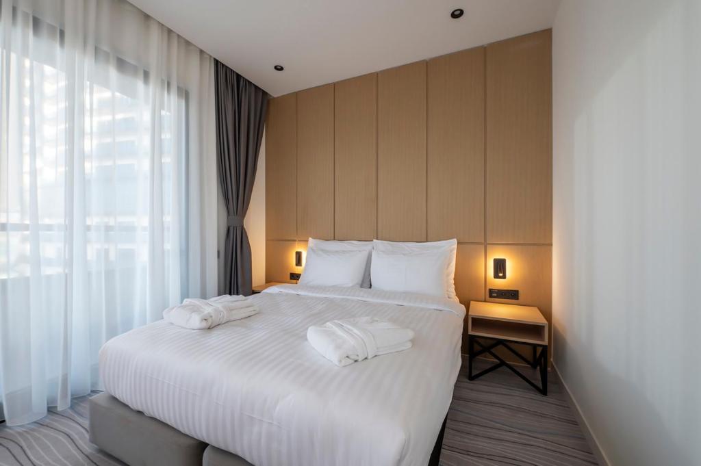 Mūsdienīga guļamistaba ar divguļamo gultu, gaismu un logiem, kas nodrošina dabīgu apgaismojumu. Interjers ir gaišs un elegants, radot relaksējošu atmosfēru.