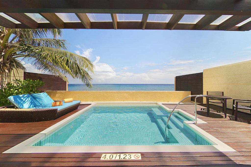 Luksusa viesnīcas numura terase ar privātu baseinu, dīvānu un skatu uz jūru. Ideāla vieta relaksācijai un atpūtai.