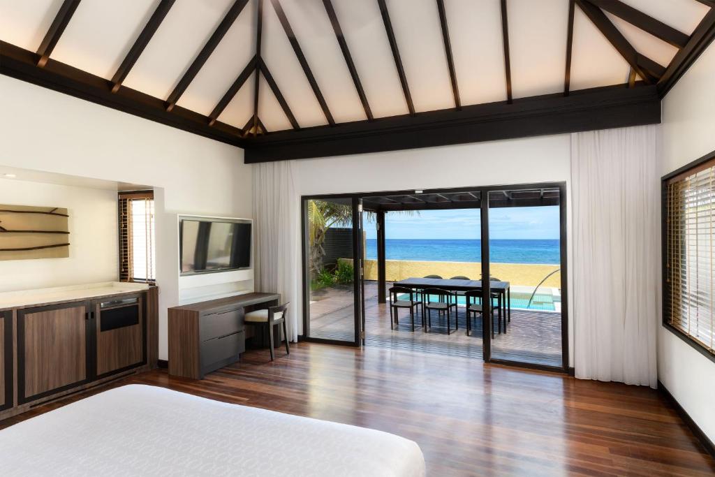 Mūsdienīga viesnīcas istaba ar skatu uz jūru, kas piedāvā komfortablu iekārtojumu un piekļuvi terasei ar baseinu. Interjers ir gaišs un elegants, ar koka grīdu un mūsdienīgu tehniku.