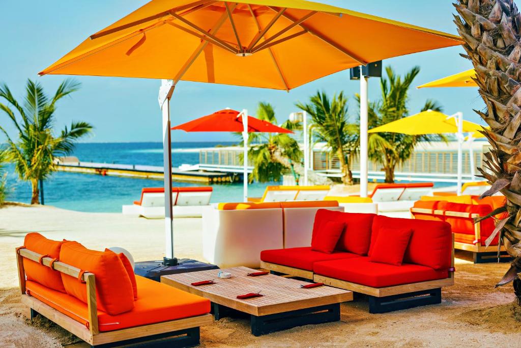 Pludmales atpūtas zona Voco Monaco Dubai ar krāsainām mēbelēm.