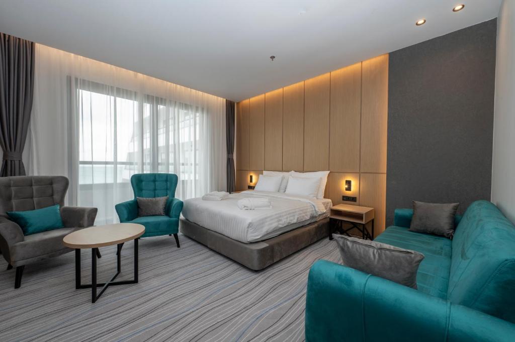 Mūsdienīga viesnīcas numura interjers ar gaisīgu atmosfēru, ērtiem mēbeļu komplektiem un dabisko apgaismojumu. Ideāla vieta relaksācijai un atpūtai.