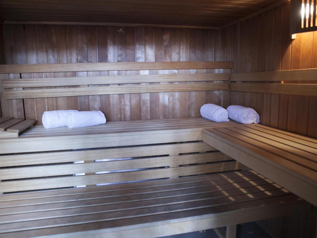 Koka pirts ar koka sienām un plauktiem, kur atrodas balti dvieļi. Ideāla vieta relaksācijai un atjaunošanai.