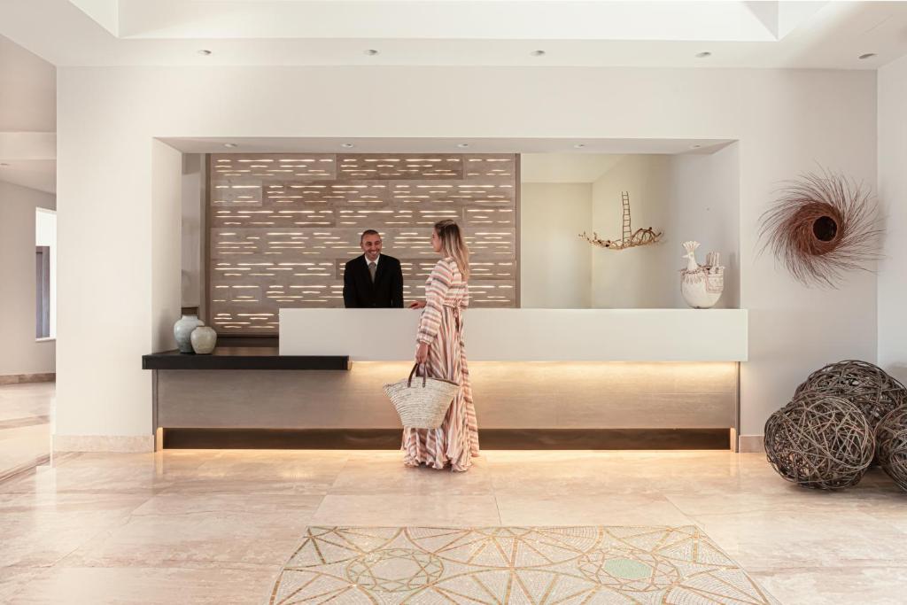 Cala Cuncheddi viesnīcas reģistratūra ar viesi un darbinieku