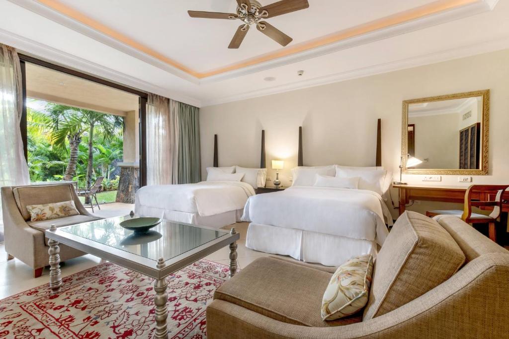 Greznas viesnīcas numura interjers ar divām gultām, modernu mēbelējumu un plašu terasi, no kuras paveras skats uz zaļo dārzu. Eleganta atmosfēra un komforts nodrošina patīkamu atpūtu.