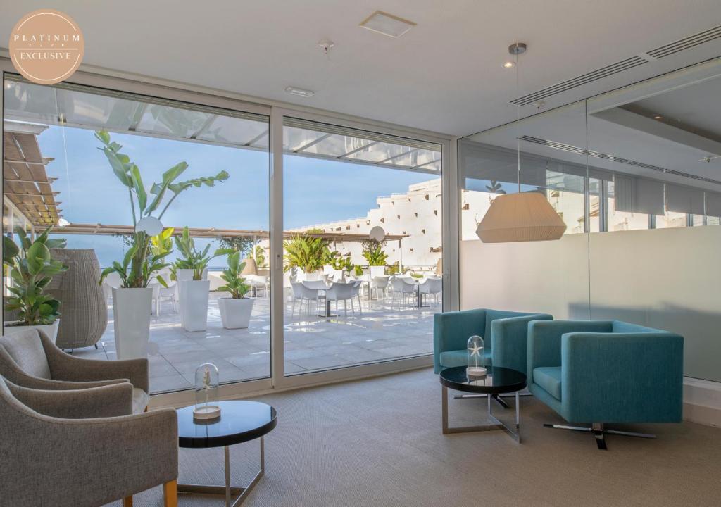 Moderns interjers ar ērtiem krēsliem un skatu uz terasi, kurā ir zaļumi un ēdamzona. Gaisīgs un elegants dizains radīs patīkamu atmosfēru.