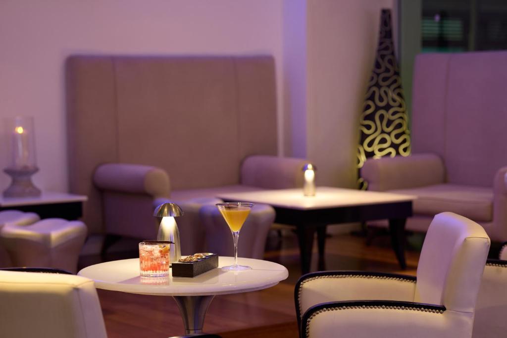 Elegants interjers ar dīvāniem un galdiņiem, kur redzami kokteiļi un sveces, radot relaksējošu atmosfēru. Ideāla vieta atpūtai un socializēšanai.