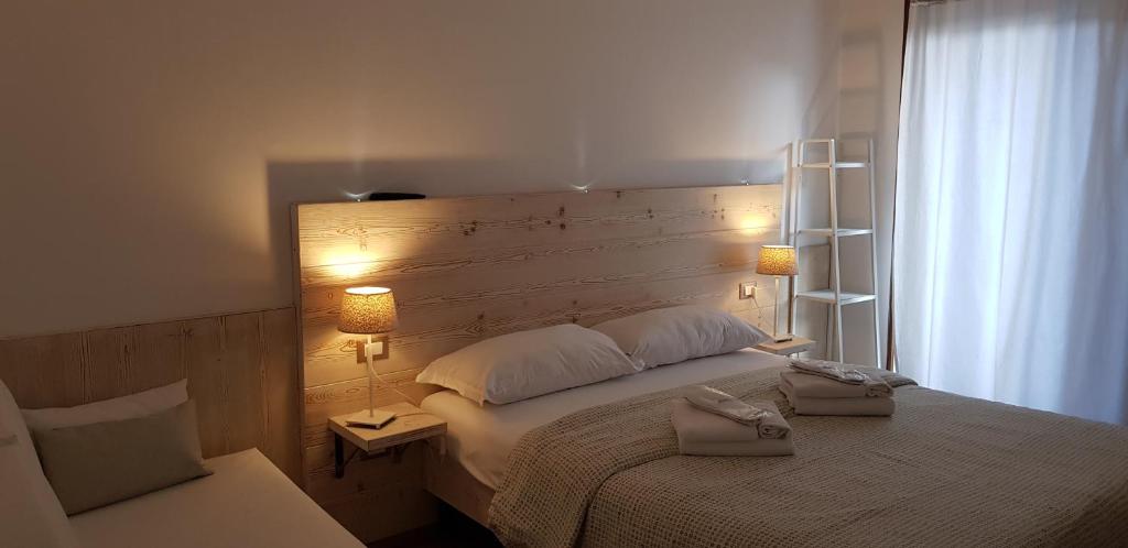 Mūsdienīga guļamistaba ar koka interjeru, gaismas lampām un baltām aizkariem. Telpa ir ērta un mājīga, piemērota atpūtai.