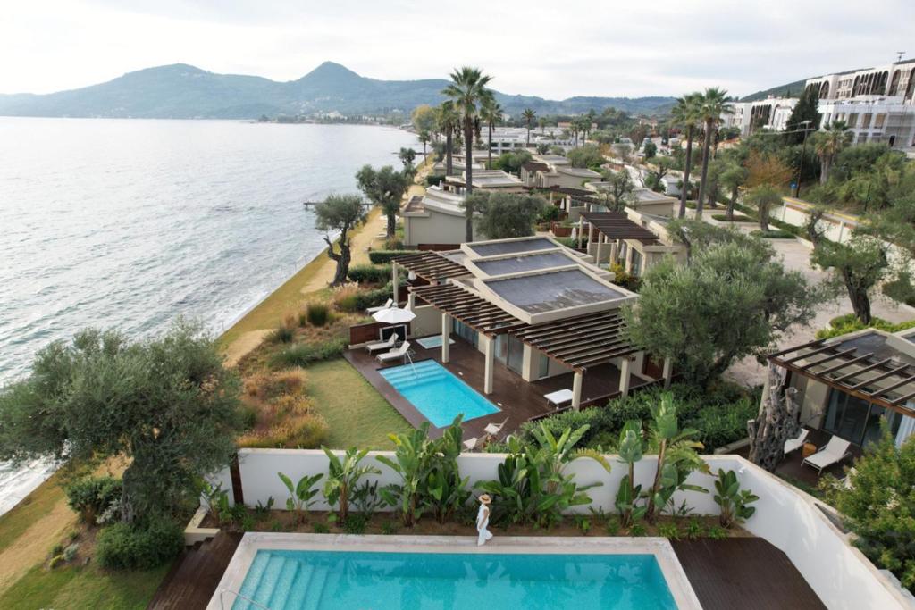 Luksusa kūrorts pie jūras ar privātiem baseiniem un palmām, kas ieskauj modernās villas. Skaists skats uz kalniem un mierīgu ūdeni.