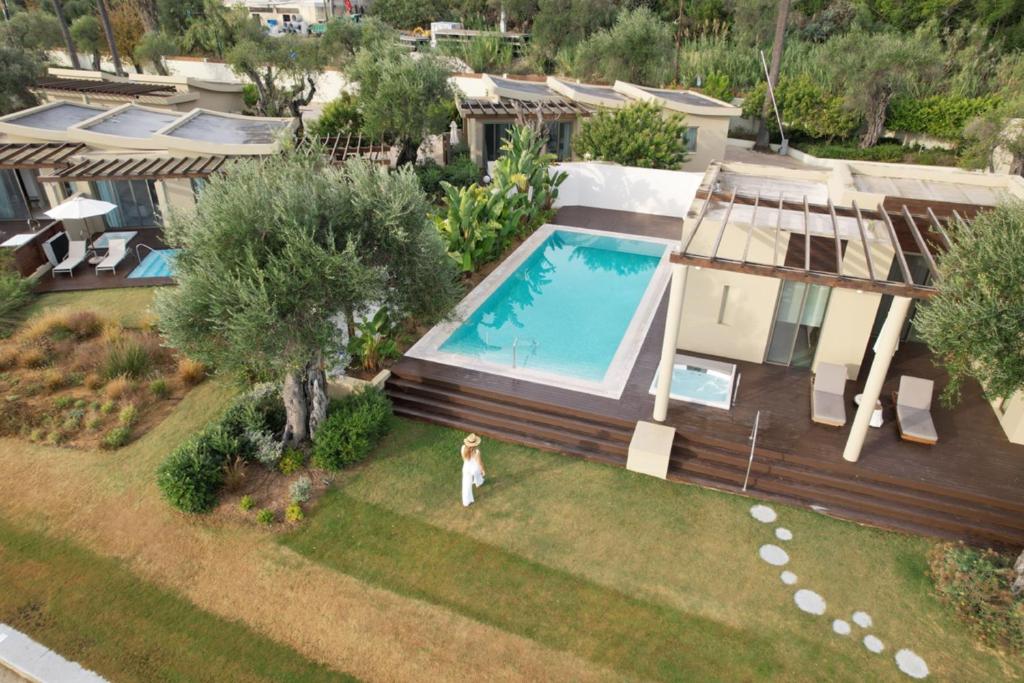 Mūsdienīga villa ar peldbaseinu un ainavu, kurā ir zaļi dārzi un palmām. Ideāla atpūtas vieta ar elegantu dizainu un komfortu.