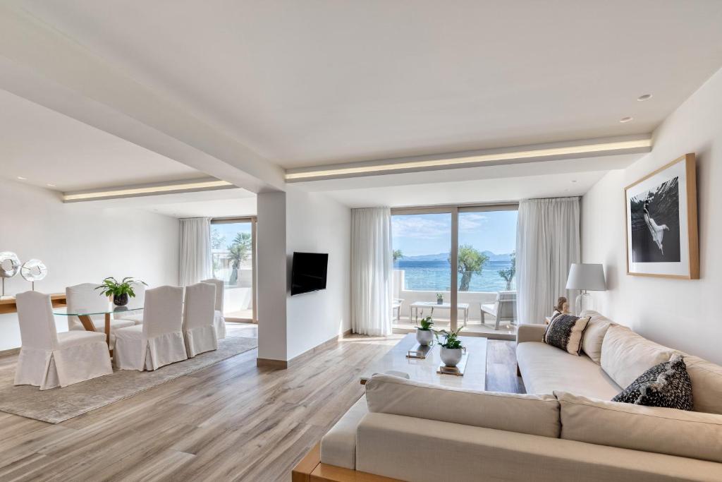 Mūsdienīgs dzīvoklis ar plašu viesistabu un panorāmas skatu uz jūru. Interjērā ir gaismas toņi un mūsdienīgas mēbeles, radot komfortablu un elegantu atmosfēru.