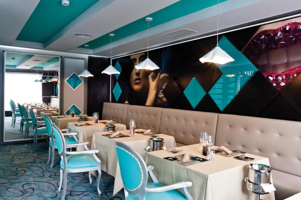 Mūsdienīgs restorāns ar elegantām ēdamvietām un izteiktu interjeru, kurā dominē tumši un gaiši toņi, kā arī mākslinieciskas sienu gleznas. Stilīgas lampas un eleganta galda uzstādīšana rada komfortablu atmosfēru.