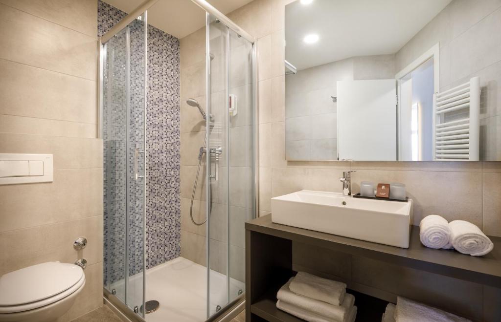 Mūsdienīga vannas istaba ar stikla dušu, elegantu izskatu un labi organizētu uzglabāšanu. Iekārtota ar gaišām flīzēm un modernu sanitāro tehniku.