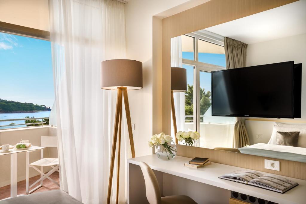 Elegants viesnīcas numurs ar skatu uz jūru, atpūtas zonu un modernu interjeru. Iekļauti gaismas elementi, kā arī plaša spoguļa un televizora klātbūtne.