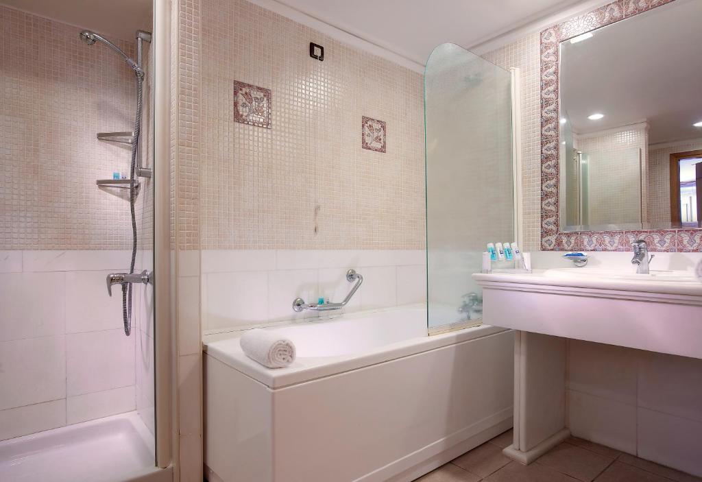 Mūsdienīgs vannas istabas interjers viesnīcā Knossos Royal ar dušu un vannu.