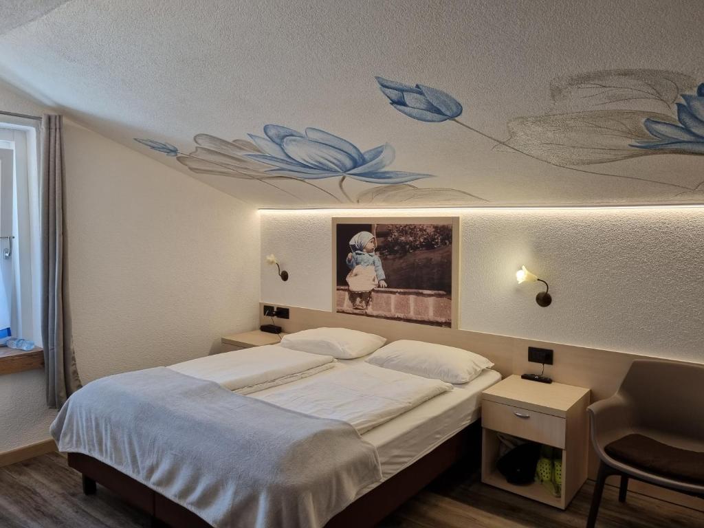 Mūsdienīga viesnīcas numura interjers ar gultu, dekoratīvu sienu gleznojumu un gaismas elementiem. Numurā ir arī koka grīda un ērtas mēbeles.