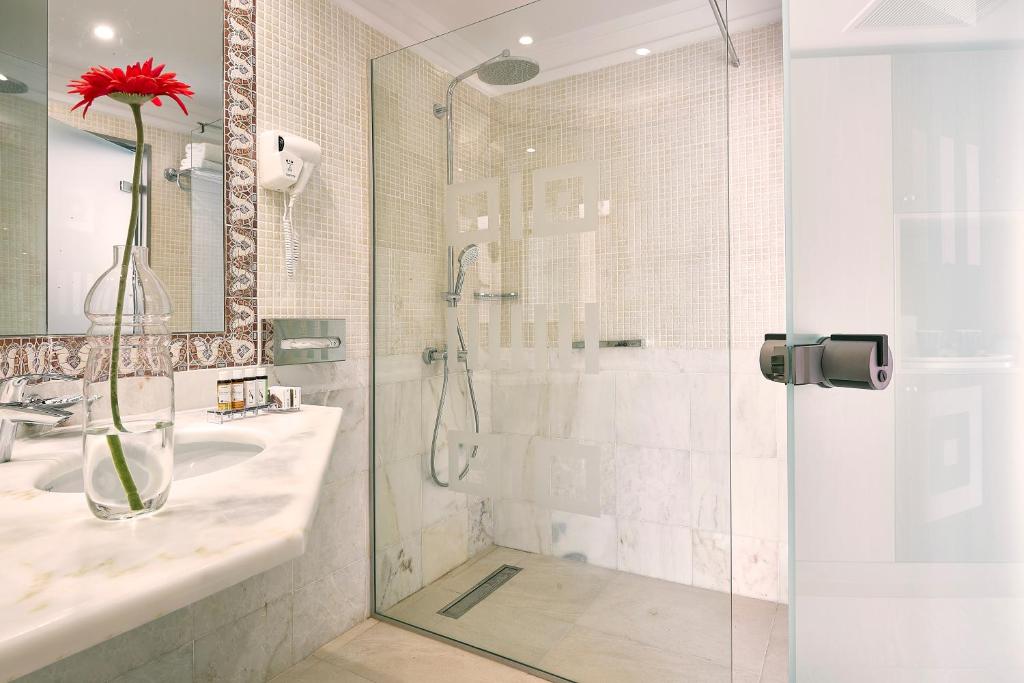 Mūsdienīgs vannas istabas dizains Knossos Royal ar stikla dušu un elegantu akcentu.