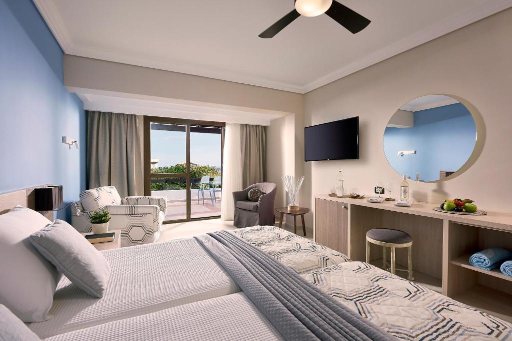 Mūsdienīgs numurs viesnīcā Knossos Royal ar balkonu un skatu uz dabu.