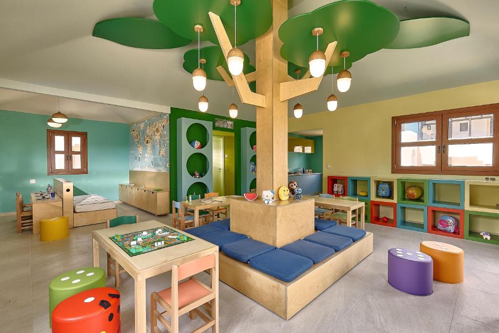 Bērnu rotaļu istaba viesnīcā Knossos Royal ar krāsainām mēbelēm un aktivitātēm.