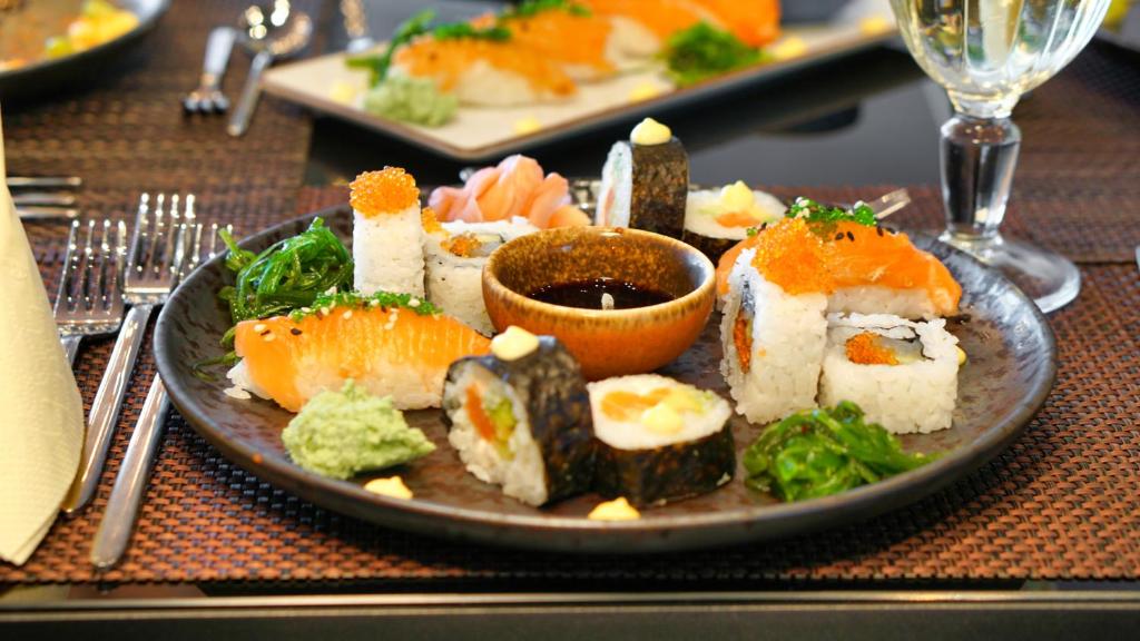 Svaigs sushi šķīvis ar laša, nori un rīsu kombinācijām, papildināts ar wasabi, sojas mērci un garnelēm. Ideāls priekšējo ēdienu un japāņu virtuves baudījums.