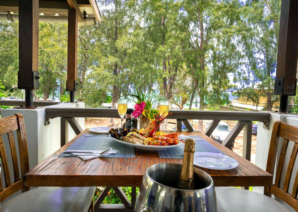 Greznas jūras veltes uz galda ar dzērieniem, kas pasniegtas terasē starp kokiem un skatu uz pludmali. Ideāla vieta romantiskai maltītei vai svinībām.