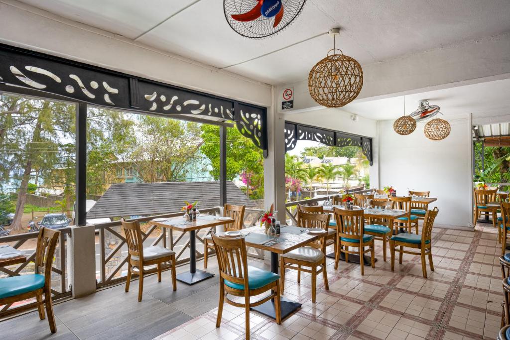 Gaišs restorāns ar modernu interjeru un viesmīlīgām koka mēbelēm, kas piedāvā skatu uz dabu. Labi aprīkots, ar ziediem uz galdiem un lieliem logiem, kas ielaida dabisko apgaismojumu.