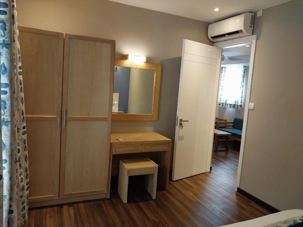 Mūsdienīga guļamistaba ar koka skapjiem, rakstāmgaldu un spoguli, kurā ir gaiši toņi un stilīga apgaismojuma. Telpā ir arī gaisa kondicionieris un logi ar aizkariem.