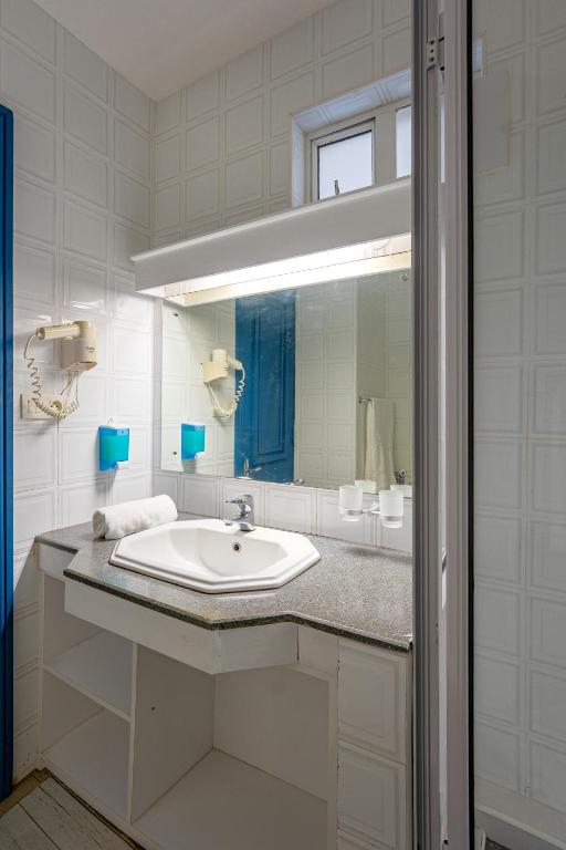 Mūsdienīgs vannas istabas izkārtojums ar gaišām flīzēm, dušas kabīni un modernu izskatu. Tajā ir izlietne ar granīta virsmu un spogulis, kas rada svaigu un tīru atmosfēru.