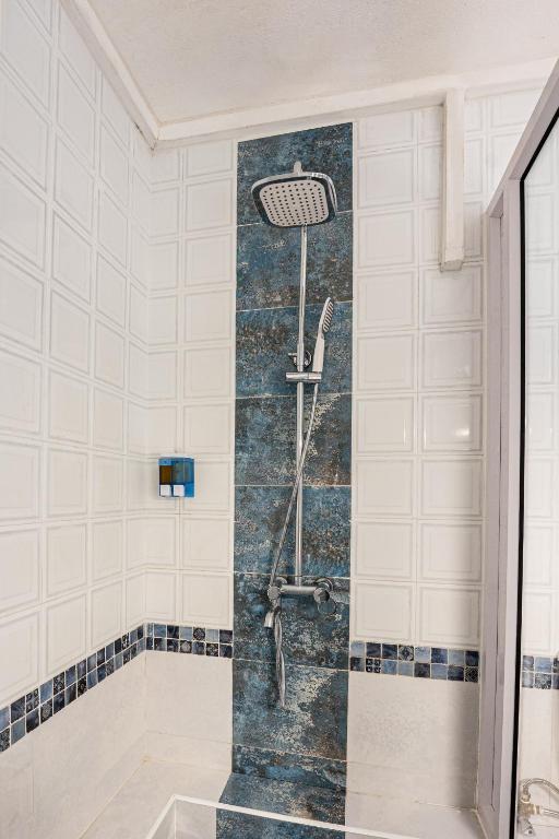 Mūsdienīga dušas zona ar elegantu, pelēku flīžu apdari un stilīgu dušas galvu. Šī telpa ir ideāla relaksācijai un atpūtai.