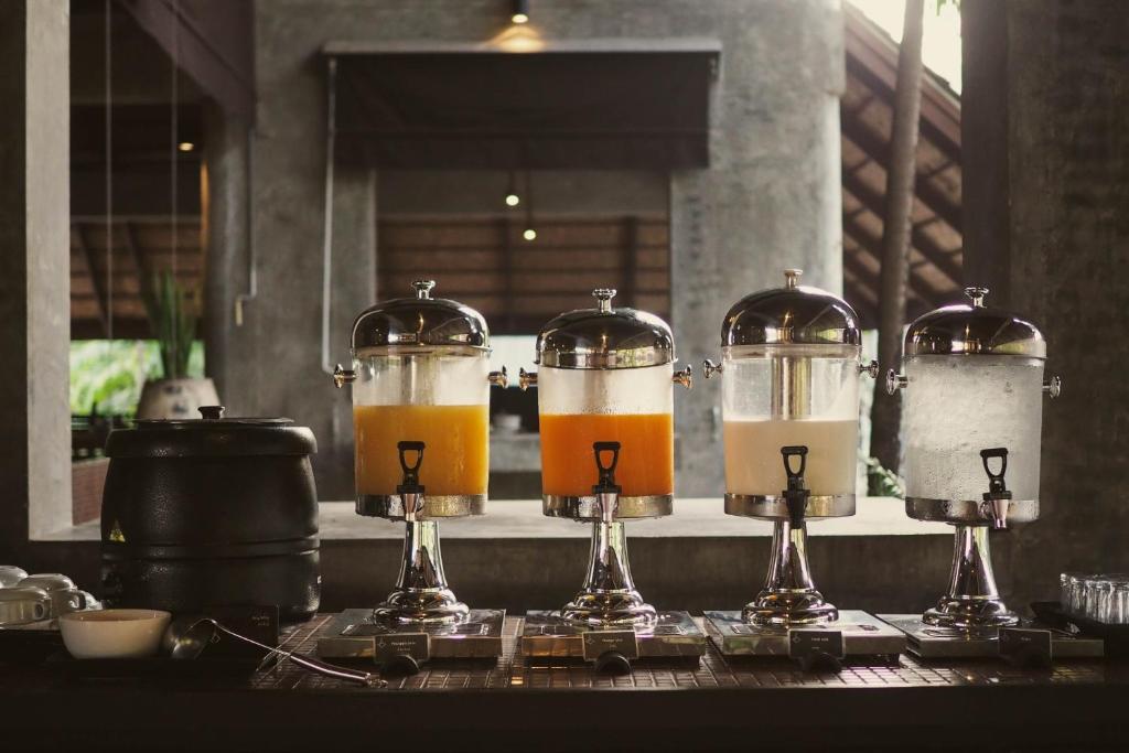 Dzeramais stends ar dažādām sulām un ūdeni, izvietots modernā interjerā. Eleganti trauki piešķir stilīgu izskatu.