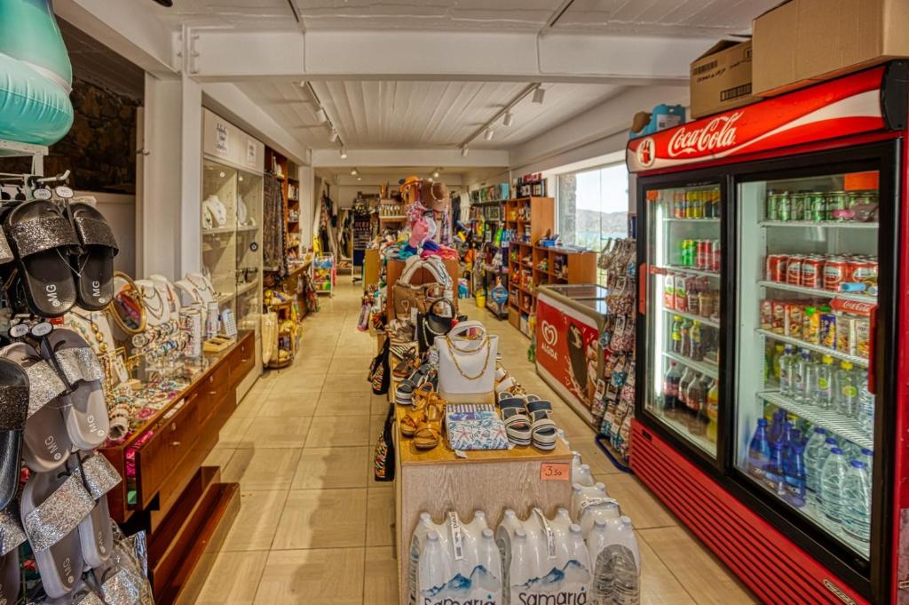 Veikala iekšskats ar dažādiem aksesuāriem, apaviem un dzērieniem uz plauktiem, tostarp Coca-Cola ledusskapi.