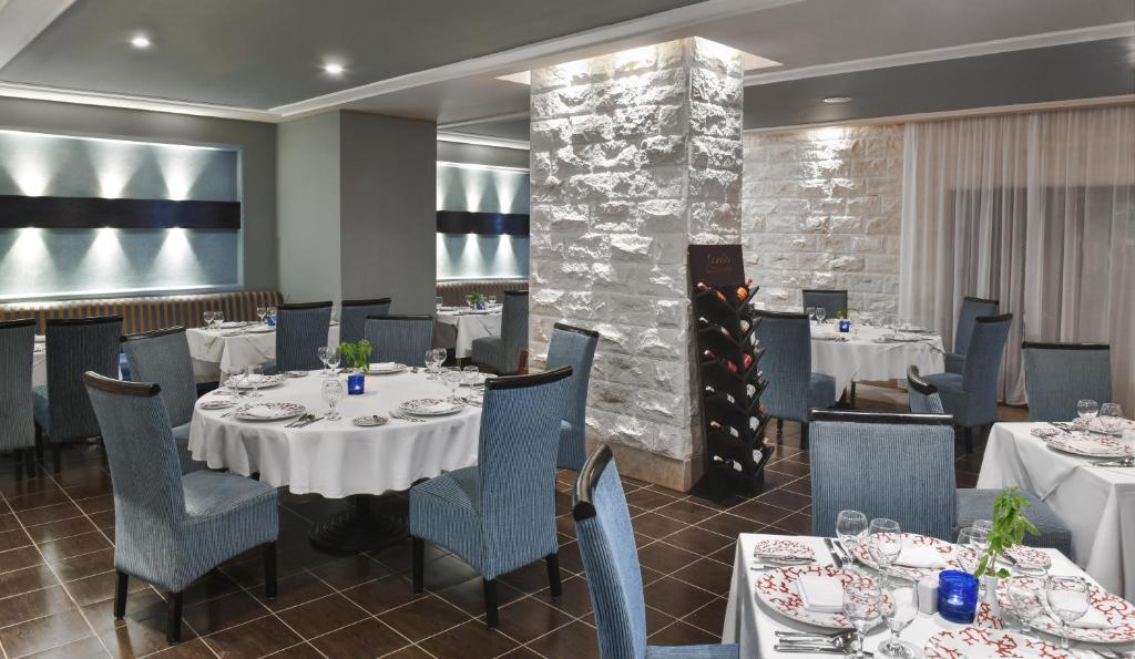 Elegants restorāns viesnīcā Jaz Aquamarine Resort ar izsmalcinātiem galdiem.