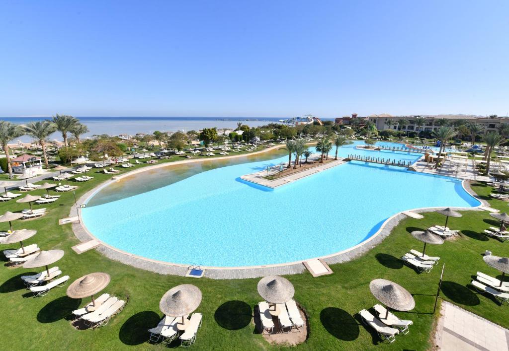 Skaists baseins pie Jaz Aquamarine Resort ar saulessargiem un jūru fona.