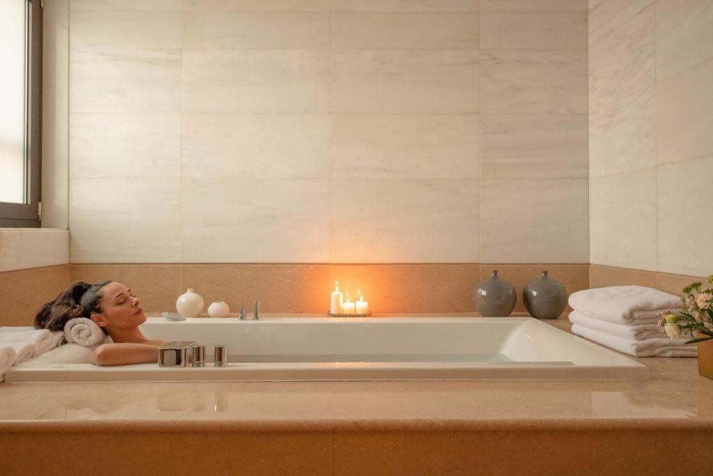 Relaksējoša vanna Sheraton Rhodes Resort spa, ar svecēm un dvieļiem.