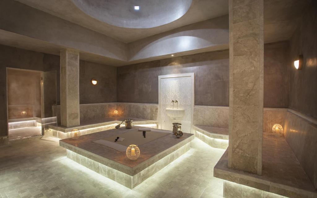 Mūsdienīga un eleganta pirts ar akmens apdari un maigu apgaismojumu, kas rada relaksējošu atmosfēru. Telpa ir aprīkota ar sēdvietām un dekoratīvām lampām, kas papildina kopējo dizainu.