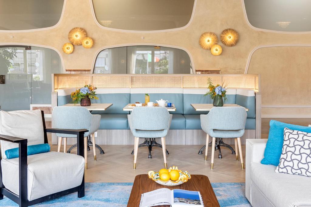 Mūsdienīgs interjers ar ērtām krēslām un elegantu galdu, kas klāts ar brokastu ēdieniem un ziediem. Gaismas elementi piešķir siltumu un viesmīlību telpai.