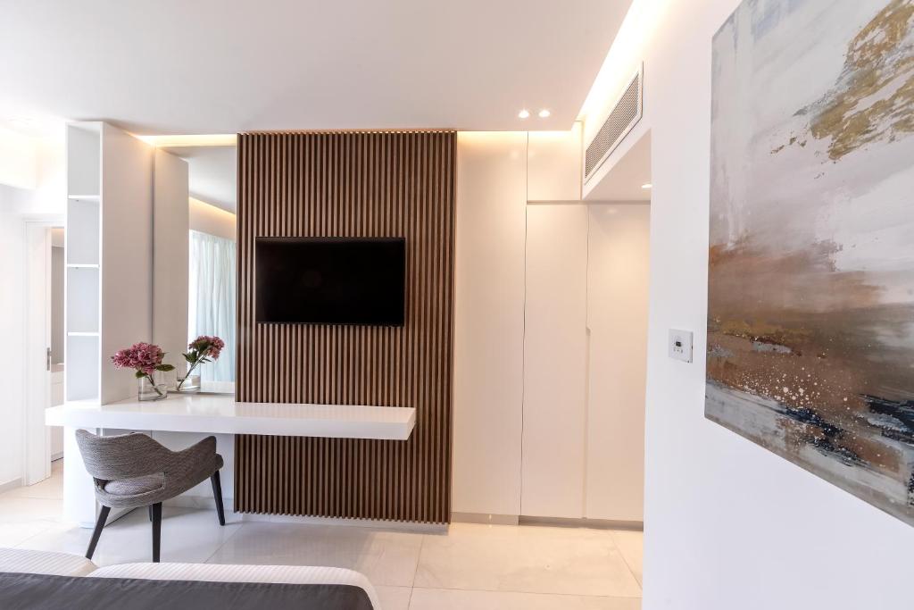 Mūsdienīga guļamistaba ar elegantu dizainu, kas ietver koka apdari, televizoru un mākslas darbu uz sienas. Telpā redzamas arī ziedu kompozīcijas un modernai mēbelei raksturīga komforta sajūta.