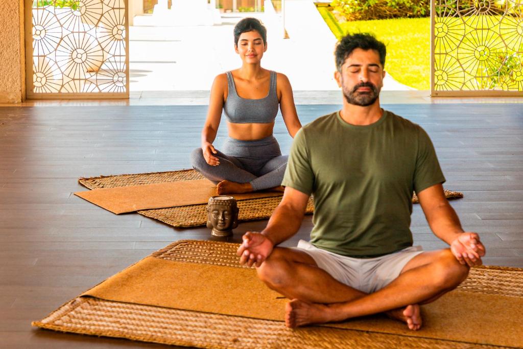 Meditācija Paradisus Playa del Carmen, pārī sēžot uz paklājiem.