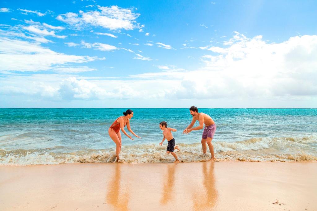 Ģimene spēlējas pludmalē pie Paradisus Playa del Carmen.
