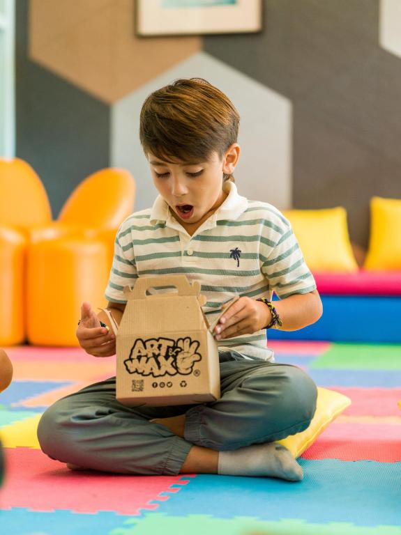 Bērns atver radošo kasti bērnu kluba aktivitātēm Paradisus Playa del Carmen.