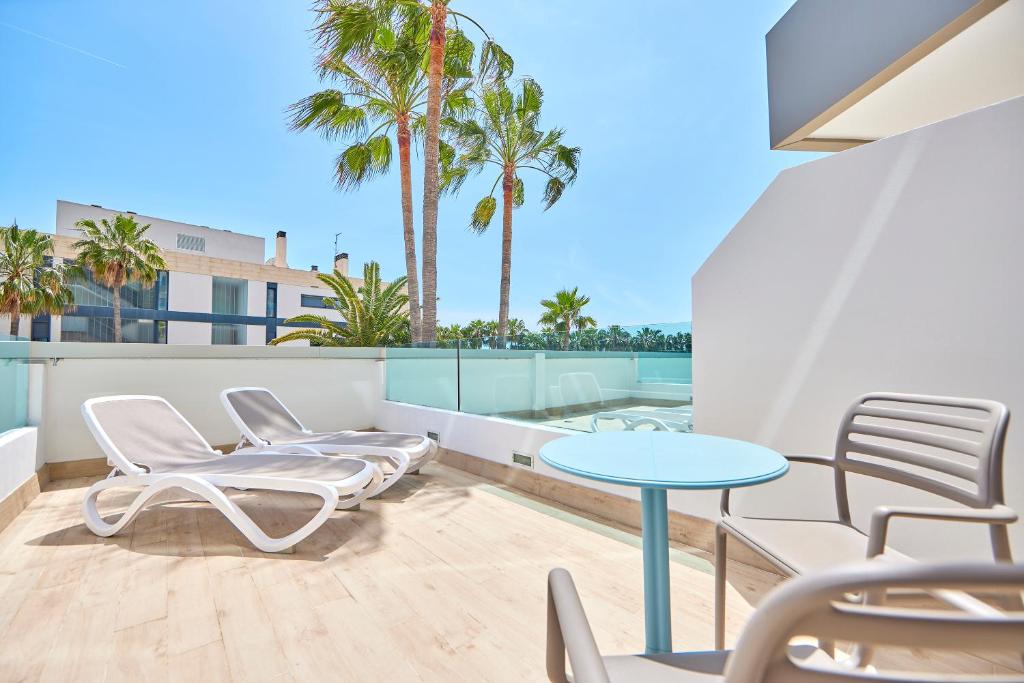 Saulaina terase ar atpūtas krēsliem un stikla barjeru, apzaļumota ar palmām. Ideāla vieta relaksācijai un skatu baudīšanai.