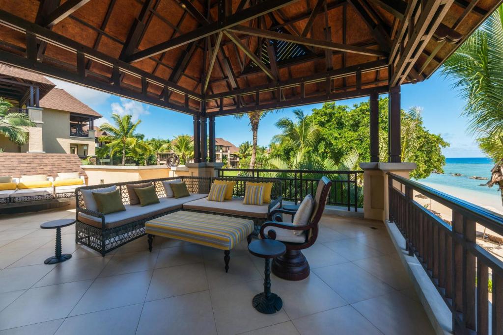 Lieliska terase ar atpūtas zonu, kurā redzami dārzi, palmas un skats uz jūru. Ideāla vieta relaksācijai un atpūtai.