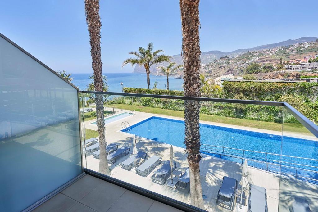Skats no balkona uz baseinu un jūru, apkārt palmām un kalniem. Ideāla vieta atpūtai un atpūtas brīžiem.