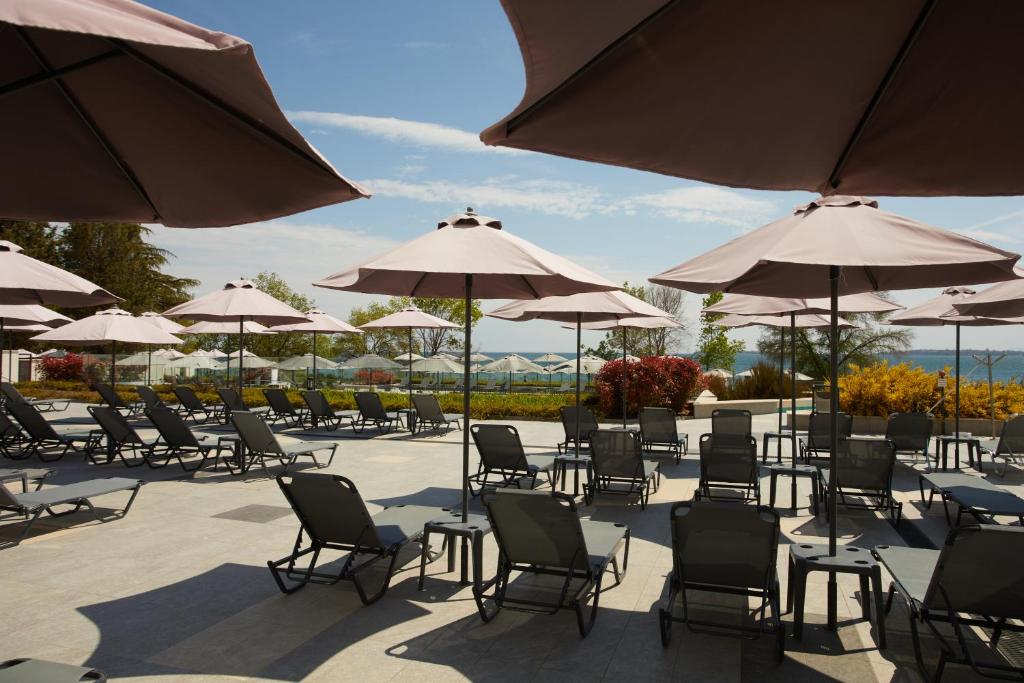 Sauļošanās krēsli un lietussargi pie pludmales, ar skatu uz jūru. Ideāla vieta atpūtai un relaksācijai.