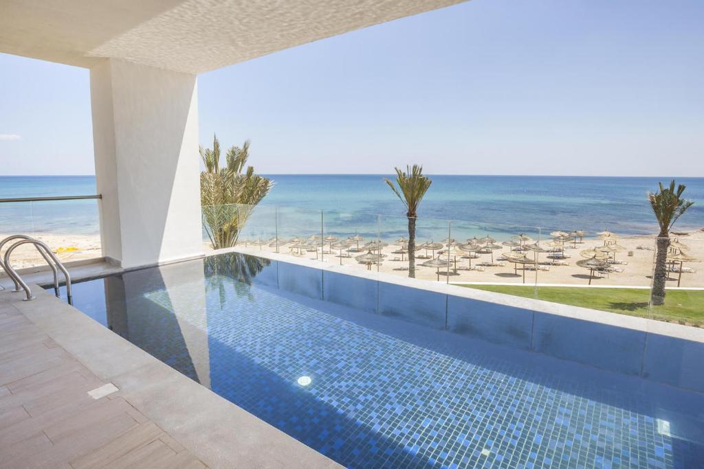 Peldbaseins ar skatu uz pludmali un jūru, apzaļumotas palmas un saulē iemirdzošs ūdens. Ideāla vieta relaksācijai un atpūtai.